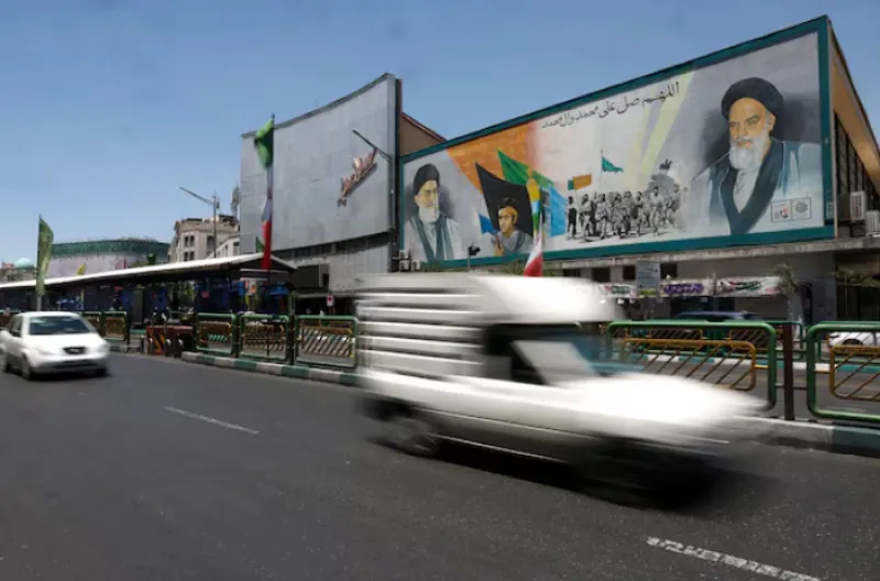 Orang-orang berkendara melewati mural yang menggambarkan mendiang pemimpin Revolusi Islam, Ayatollah Ruhollah Khomeini, dan mendiang Pemimpin Tertinggi Iran, Ayatollah Ali Khamenei, di sebuah jalan di Teheran,