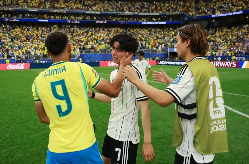 Matheus Cunha dari Brasil mencoba menghibur Ao Tanaka dari Jepang di akhir pertandingan babak 32 besar Piala Dunia di Houston