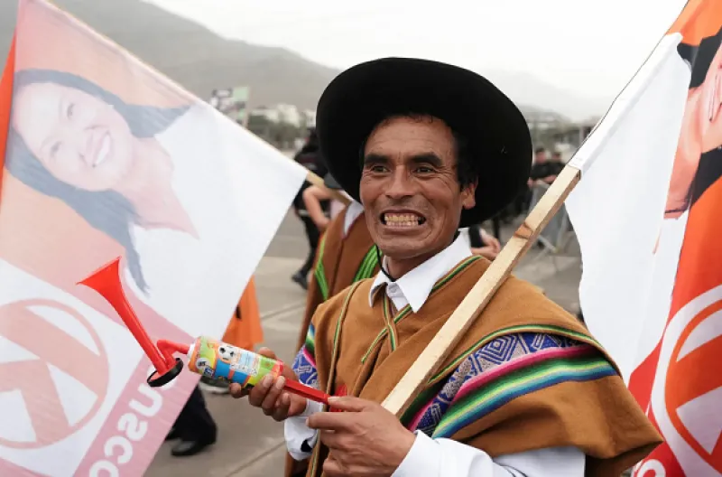 Seorang pendukung Keiko Fujimori mengibarkan bendera sebagai bentuk dukungan terhadap kampanyenya sambil menunggu rapat umum terakhir