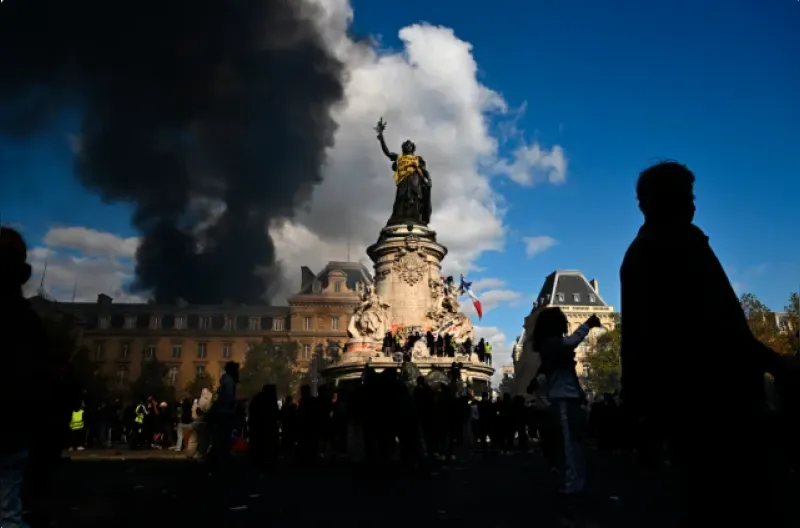 Para pengunjuk rasa menyelimuti patung di Place de la Republique dengan rompi kuning saat bentrokan meletus selama demonstrasi untuk memprotes tingginya biaya hidup.