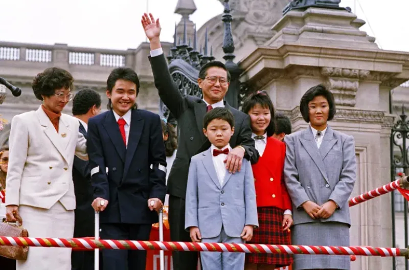 Presiden Alberto Fujimori melambaikan tangan kepada para pendukungnya pada 8 Juli 1990, didampingi oleh istrinya Susana Higuchi dan Keiko Fujimori yang berusia 15 tahun di paling kanan