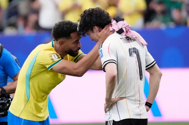 Matheus Cunha dari Brasil menghibur Ao Tanaka dari Jepang di akhir pertandingan babak 32 besar Piala Dunia di Houston
