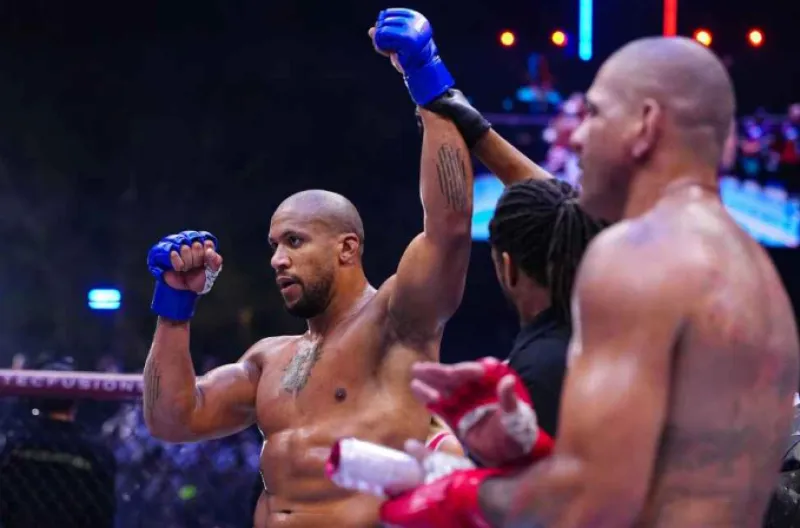 Ciryl Gane, di sebelah kiri, mengangkat tangannya sebagai tanda kemenangan setelah mengalahkan Alex Pereira untuk merebut gelar juara kelas berat interim UFC di UFC Freedom 250 di Gedung Putih.