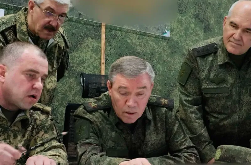 Kepala Staf Umum Rusia Jenderal Valery Gerasimov, di tengah, berbicara kepada para perwira sambil memeriksa pasukan yang terlibat dalam pertempuran di Ukraina. Kantor Berita Kementerian Pertahanan Rusia