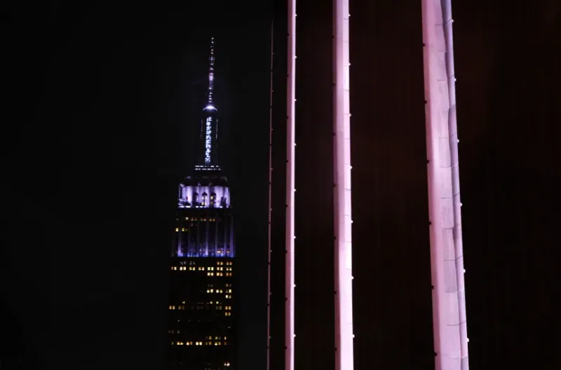 Gedung Empire State terlihat diterangi cahaya di belakang Madison Square Garden di New York pada hari Jumat.