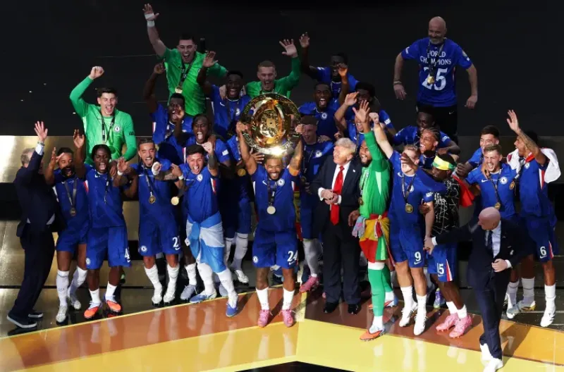 Reece James dari Chelsea mengangkat trofi saat ia merayakan kemenangan bersama rekan-rekan setimnya setelah memenangkan Piala Dunia Antarklub FIFA, dengan Presiden AS Donald Trump dan presiden FIFA Gianni Infantino juga berada di atas panggung
