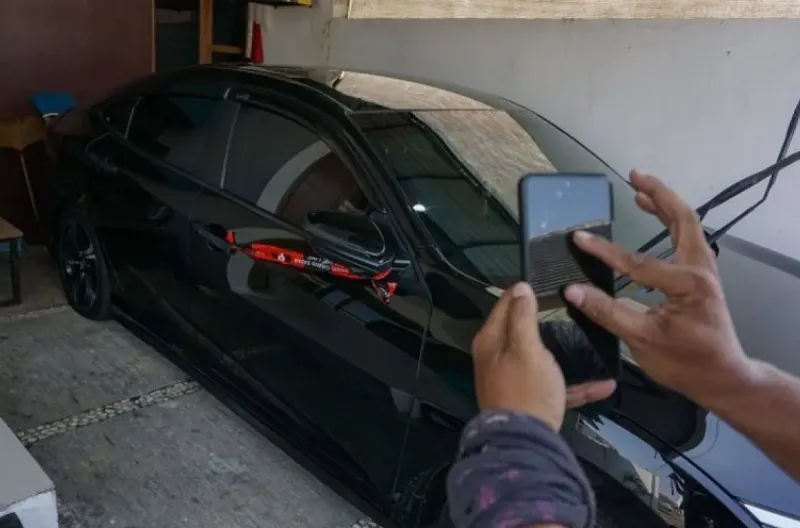 Seorang wartawan memotret mobil yang disegel KPK di salah satu rumah di Kabupaten Pemalang, Jawa Tengah, Rabu (29/7/2026). KPK menyegel kantor Kepala Dinas Pekerjaan Umum dan Penataan Ruang (PUPR) Pemalang dan dua rumah terkait adanya operasi tangkap tang