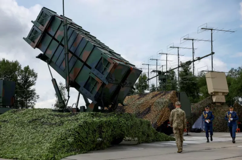 Para anggota militer Ukraina berjalan di samping peluncur sistem pertahanan udara Patriot, di tengah serangan Rusia terhadap Ukraina meningkat