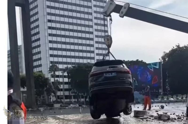 Insiden kecelakaan hari ini di Bundaran Hotel Indonesia (HI), mobil berkelir hitam tabrak pembatas nyebur kolam, Rabu (25/3/2026) dini hari. Penampakan mobil dievakuasi petugas Dishub DKI. (TMC Polda Metro Jaya)
