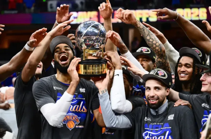 Para pemain New York Knicks merayakan kemenangan dengan Trofi Kejuaraan Larry O'Brien setelah mengalahkan San Antonio Spurs di Game 5