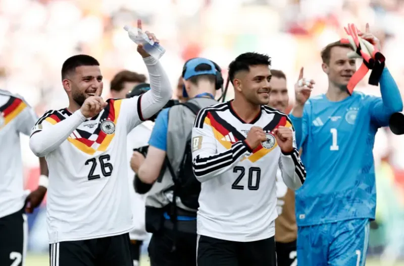 Deniz Undav dan Nadiem Amiri dari Jerman merayakan kemenangan tim mereka atas Pantai Gading, yang membuat mereka lolos ke babak knockout Piala Dunia