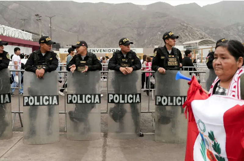 Seorang pendukung Keiko Fujimori membawa bendera Peru sementara petugas polisi berjaga di luar rapat umum penutup kandidat tersebut pada 4 Juni