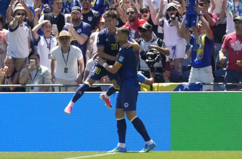 Edin Dzeko dari Bosnia dan Herzegovina dan rekan-rekan setimnya merayakan gol kedua